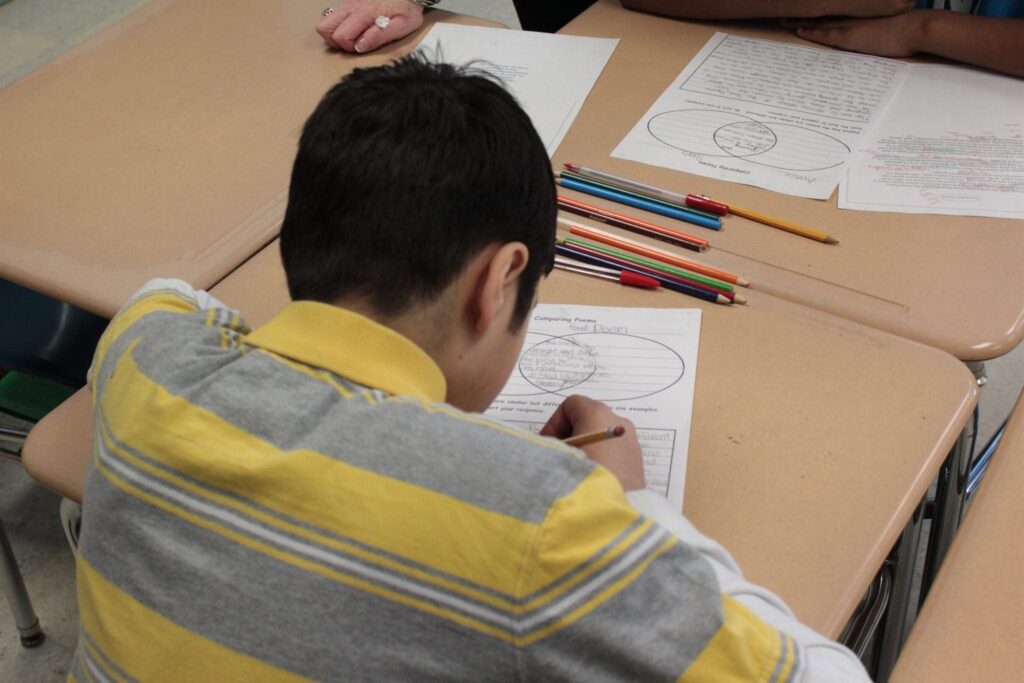 Young male student working on an assignment in the classroom