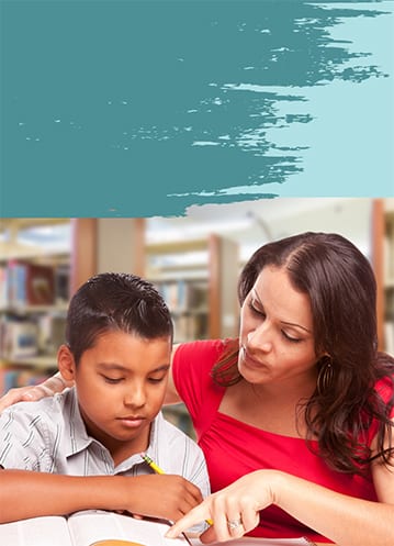 Teacher helping a student of color in library