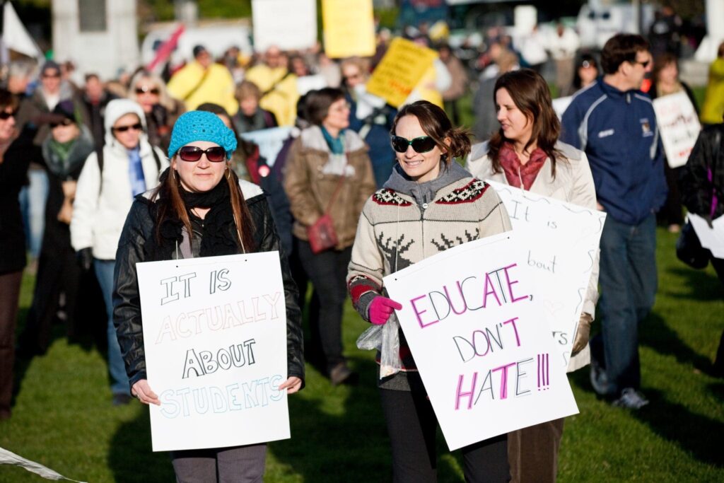 teacher protesting holding signs outdoors