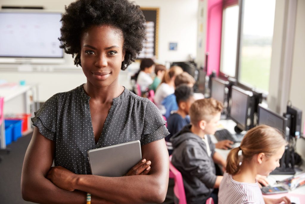 black teacher with students in the background