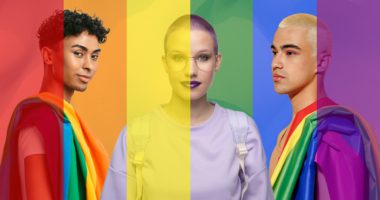 LGBTQ students against a rainbow flag