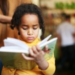 Black girl reading a children's book