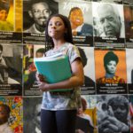 A seventh-grader walks by a Black History Month display at Sutton Middle School on her way to class.