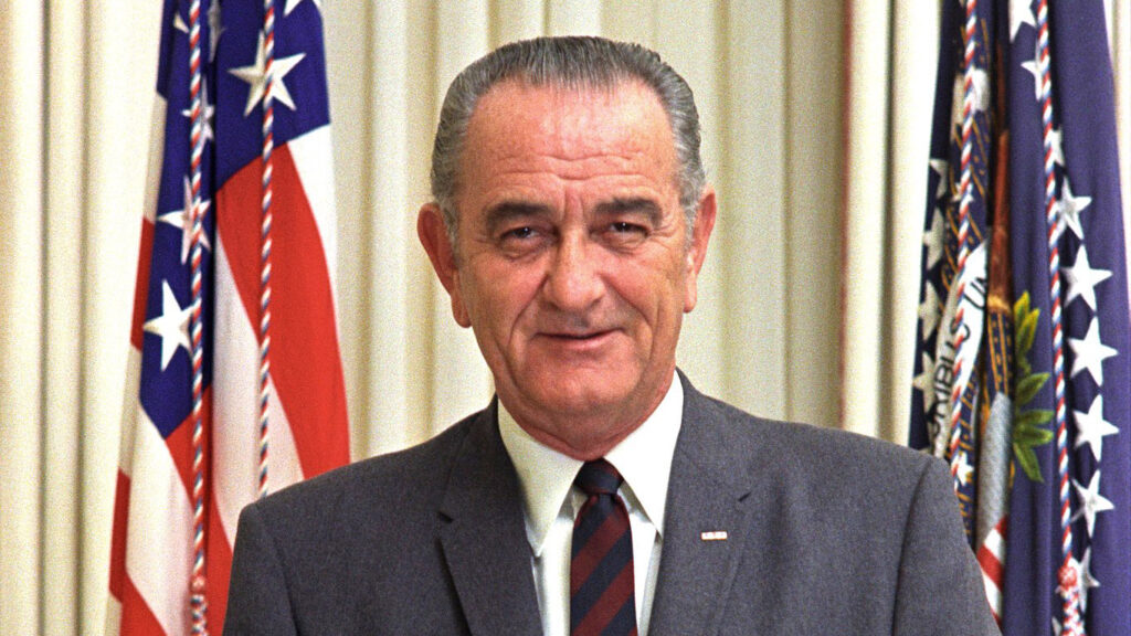 Lyndon B. Johnson portrait with flags in the background