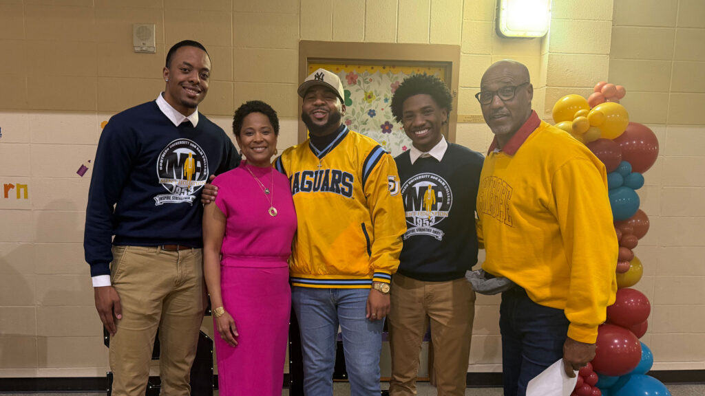 A group of five African American college students and teachers posing for a photo