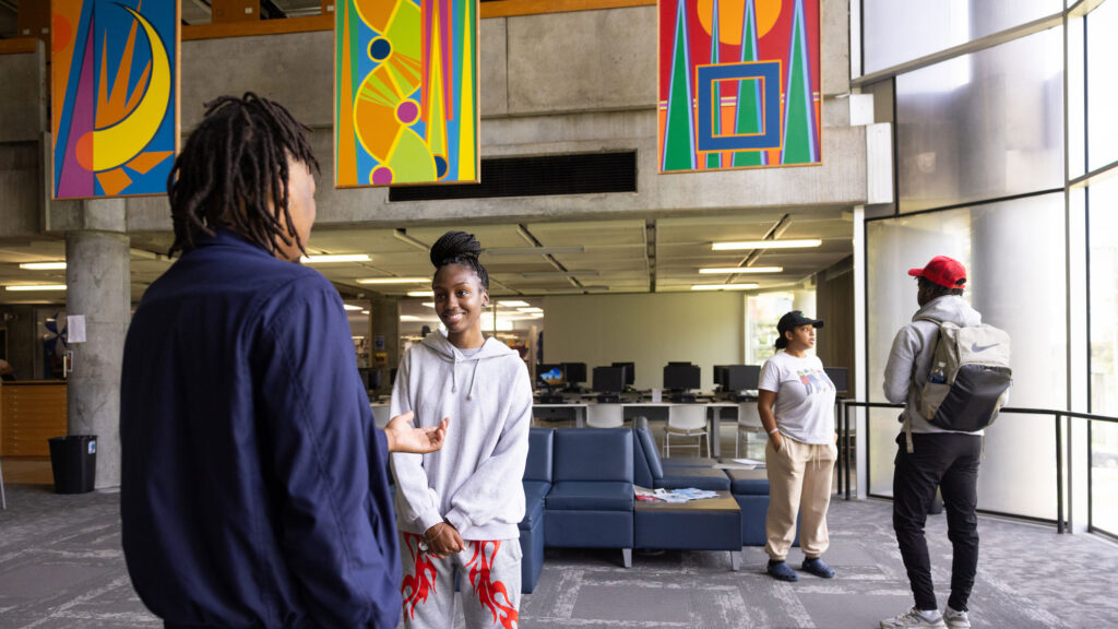 Group of Black students talking together in a common space at a college library